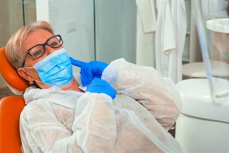 Elderly woman pointing to jaw pain while waiting for treatment from an Emergency Dentist in Ajax.